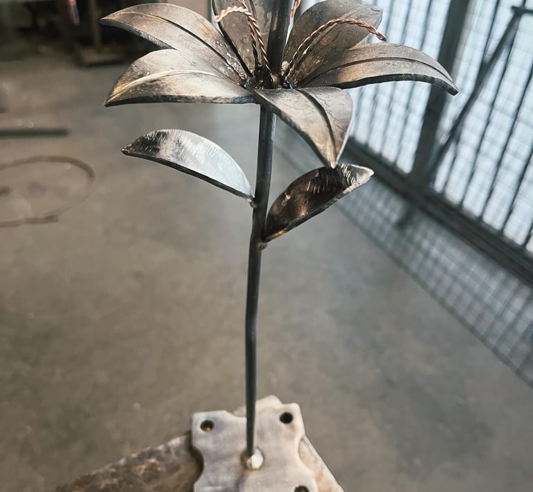 a metal flower sculpture on a wooden table