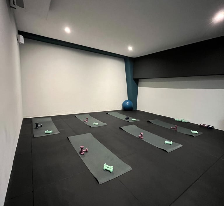 Sala fitness della palestra Move 2 Grow a Milano con tappetini, manubri e attrezzature per allenamenti di gruppo.