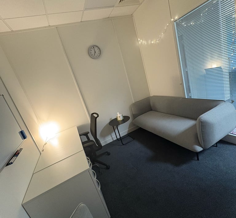 Therapy room: sofa on the right with fairy lights above, viewpoint from counselling chair