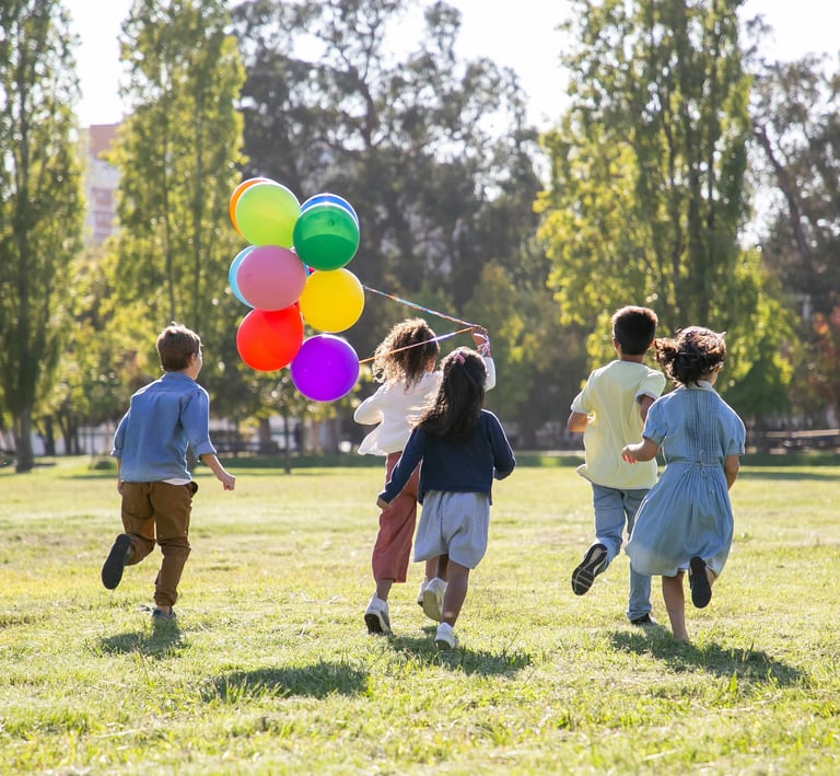 a group of children running with balloons