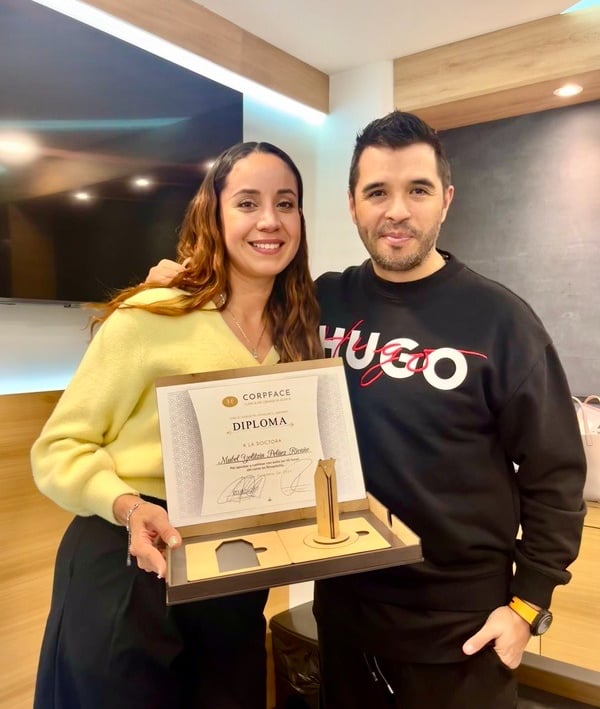 Doctora mujer recibe diploma de fellow de parte de un médico masculino