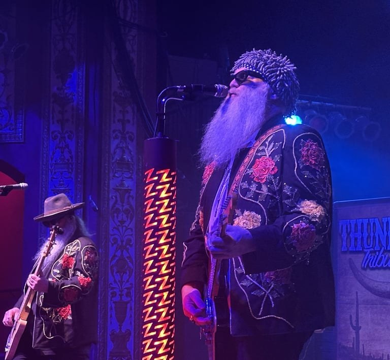 ZZ Top tribute band performing live with long beards and embroidered jackets on stage.