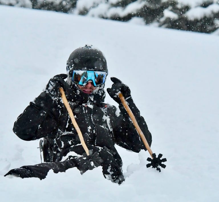 skieur enfoncé dans la poudreuse avec batons de ski en bambou