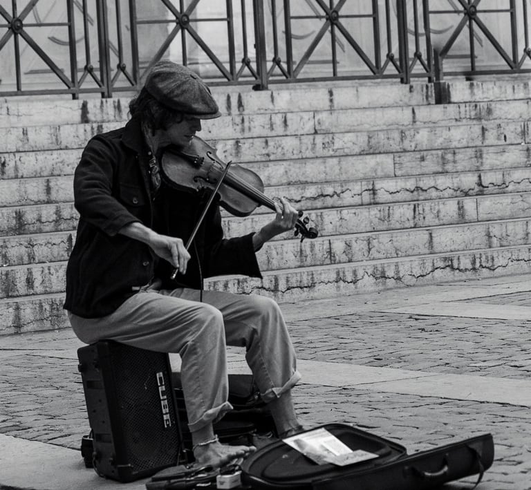 a man playing a violin on a suitcase