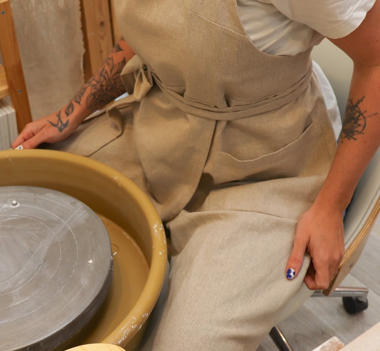 Tablier de potier en lin porté dans un atelier de céramique.