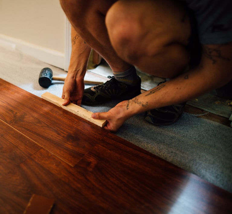 a man is using a tape measure ruler to measure a hardwood floor