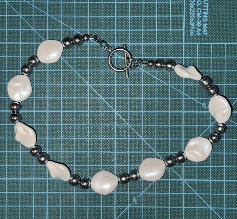Unisex necklace with irregular pearl masses and polished hematite beads, styled with a toggle clasp
