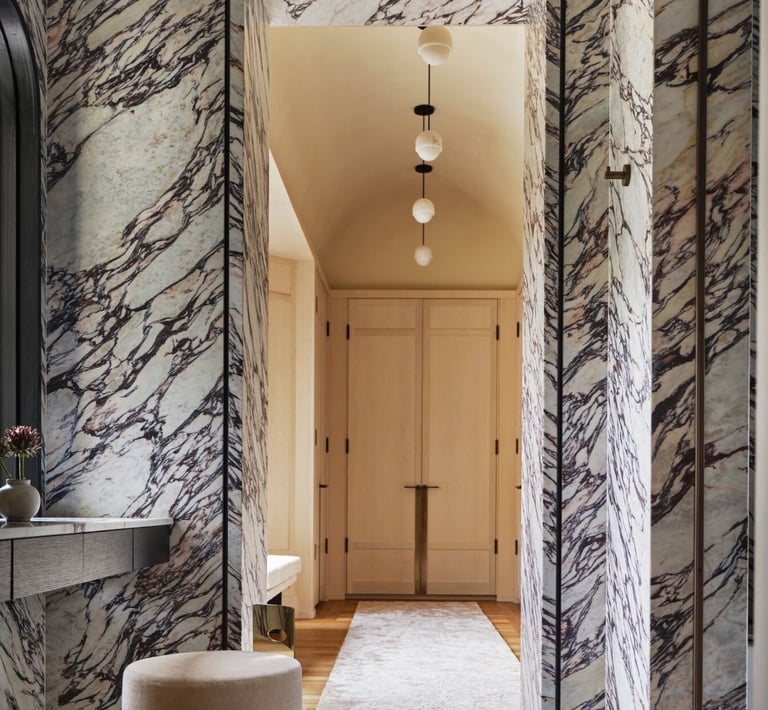 Kelly Wearstler design- bathroom with a marbled floor and a stool.