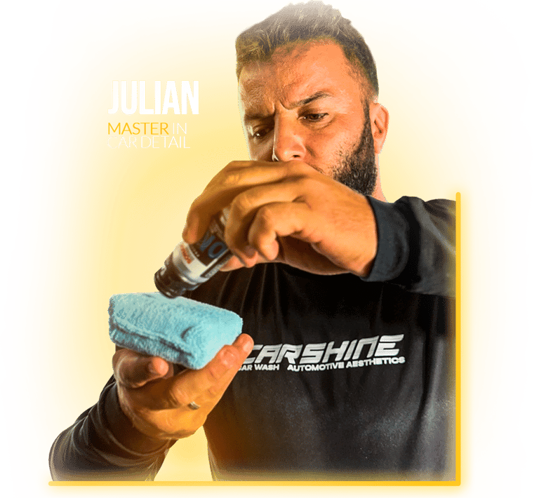 Professional car detailing specialist applying ceramic coating liquid to a blue applicator sponge.