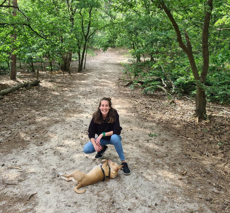 a woman and a dog sitting in the forest