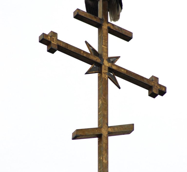 a bald eagle sitting on top of a cross