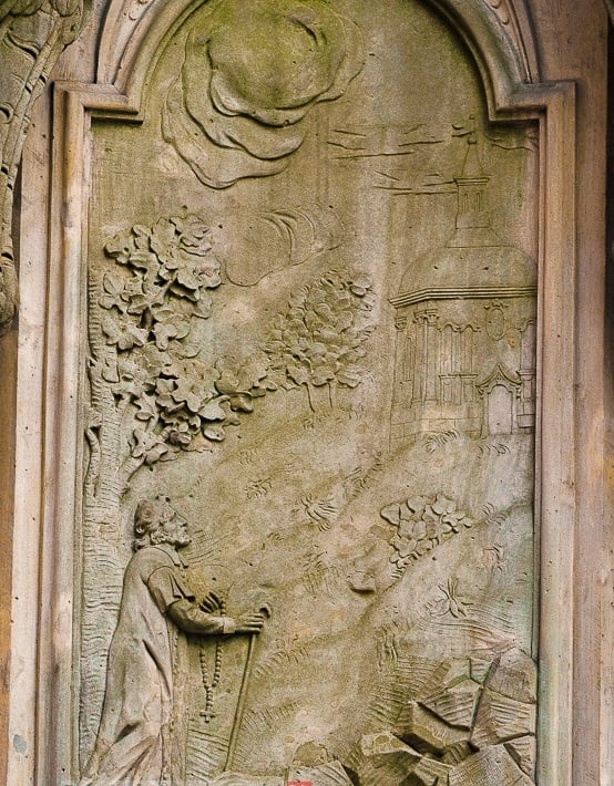 Kolejna płaskorzeźba ukazuje świętego wspierającego się na kosturze, idącego pątniczą ścieżką.