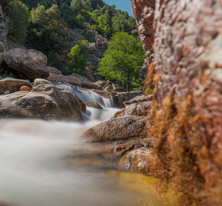 a stream of water flowing over rocks in a canyon