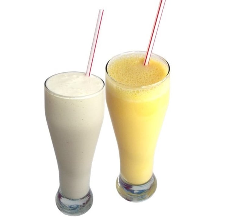 two glasses of milkshake with a drink in front of them