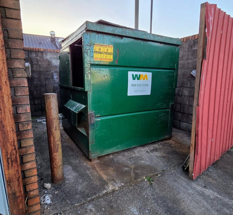Image of a dumpster area that Guaranteed Junk Removal cleaned by removing all of the trash.