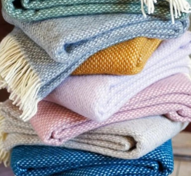 a stack of soft, colourful woollen blankets