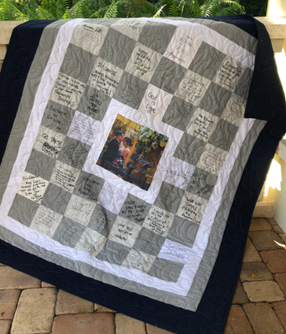 Bride and groom holding their finished signature quilt guest book