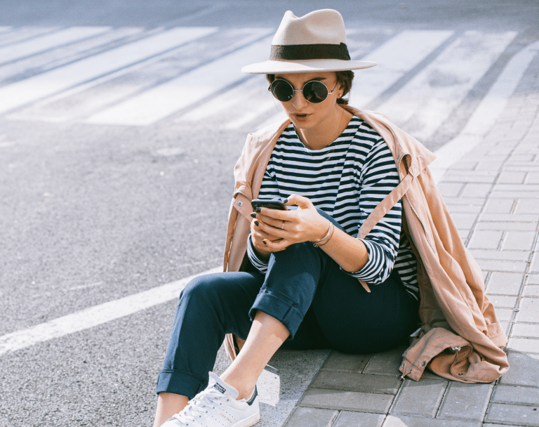 Woman pausing to reflect on life while sitting on a city street