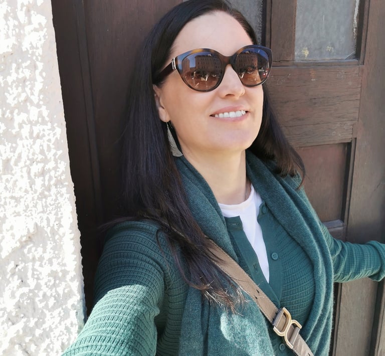 Woman with dark hair standing by a door