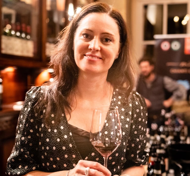 Woman with long brown hair holding a glass of red wine
