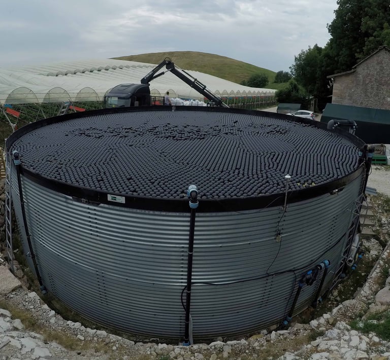 Un réservoir d'eau couvert d'enviro shade ball, limitant l'évaporation de l'eau