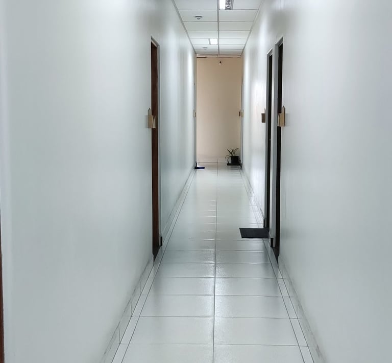 corredor com luminária e forro acústico e removível.