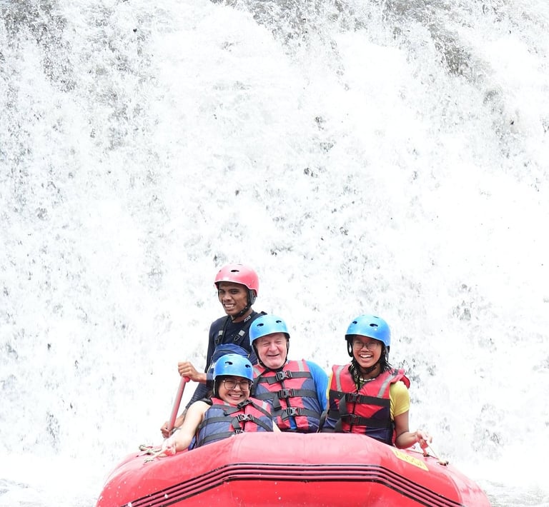Smiling group wearing helmets and life jackets during a whitewater rafting adventure on a river.