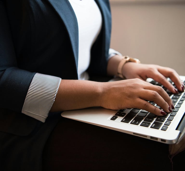 Close-up of a woman typing on a laptop offering business support to clients