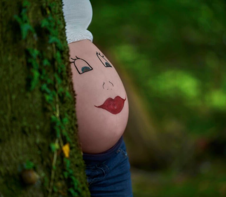a pregnant belly in green woods