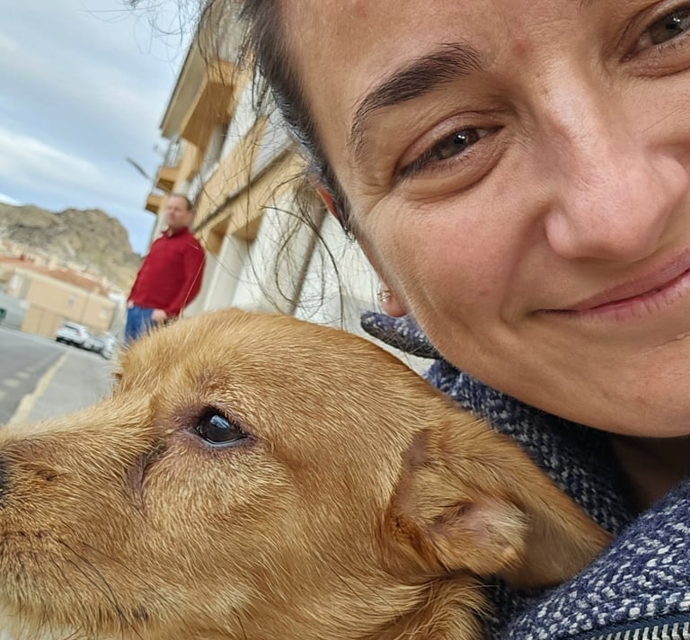 a woman in a blue jacket is holding a dog