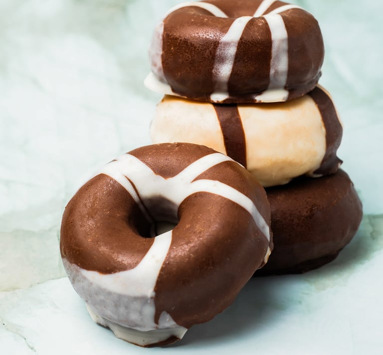 a stack of chocolate covered donuts with chocolate frosting
