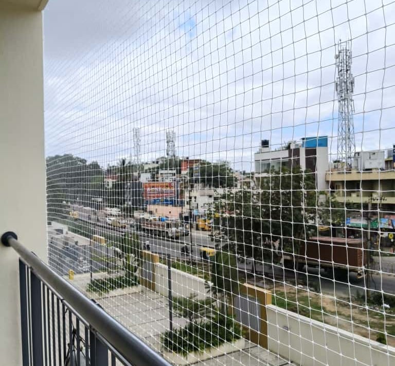 Wide-angle shot of a residential balcony fully enclosed with Arjilli Enterprises' safety net.