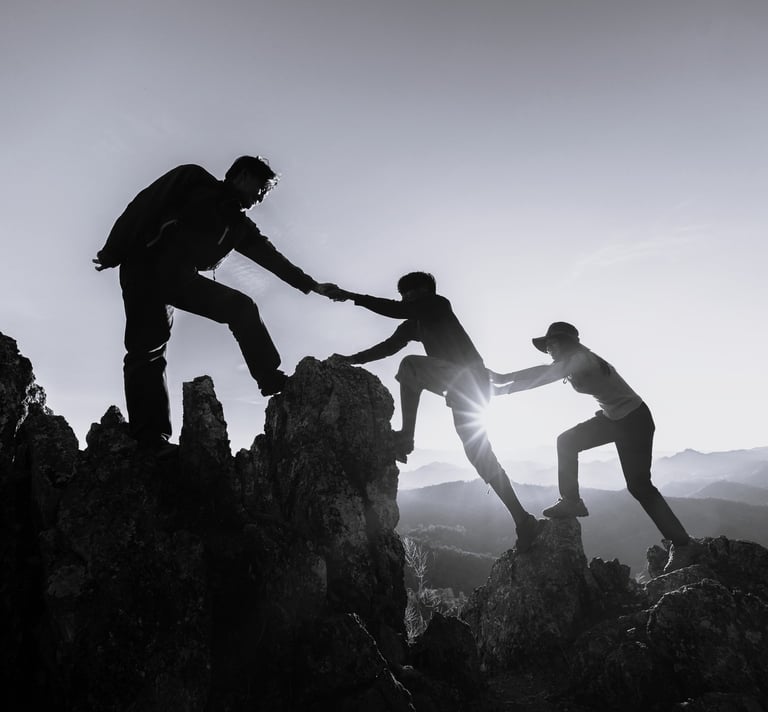 a group of people helping each other to climb up to the top of a mountain