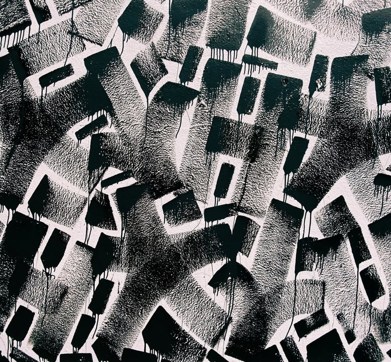 a black and white photograph of a graffiti filled wall