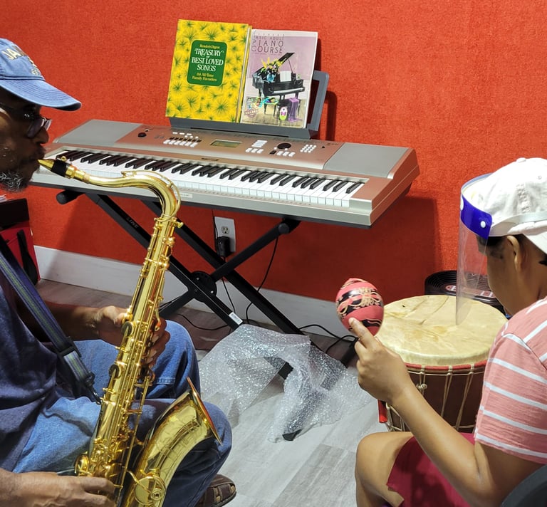 a man playing a saxophone and a woman playing playing a drum and shaking a maraca