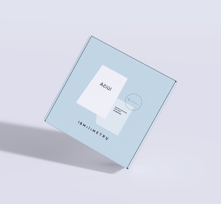 Light blue cardboard mailer box with minimalist branding and a white thank you card.