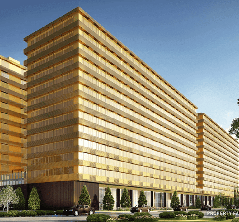 Modern luxury high-rise apartment complex with gold-tinted glass facade and urban landscaping.