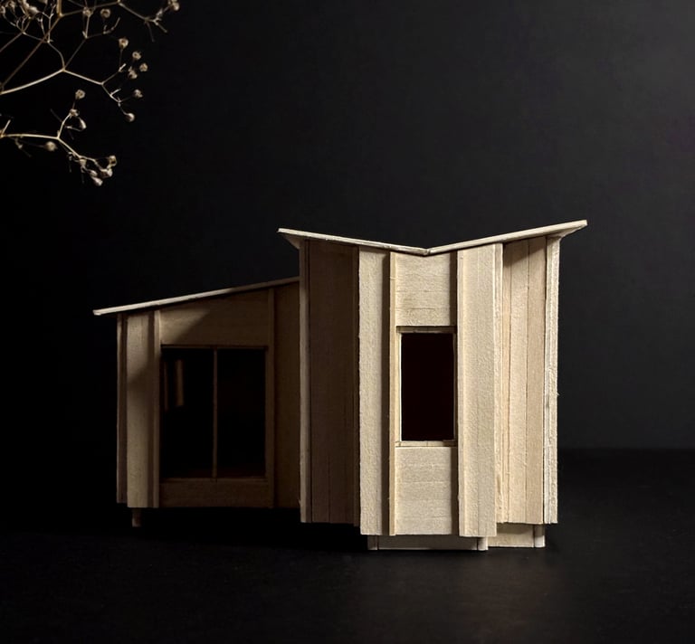 Handcrafted basswood architectural model of a modern cabin design against a dark background.