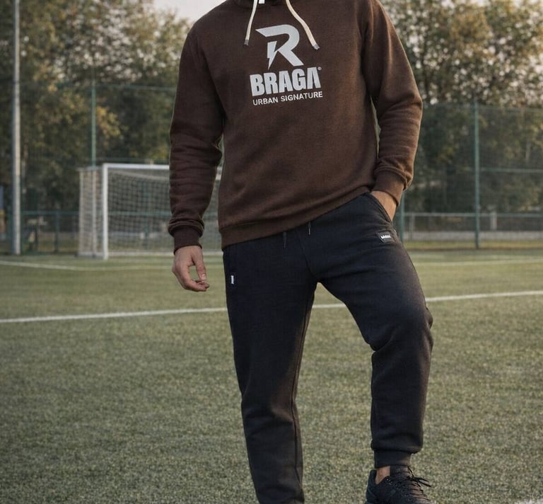 vyras futbolo aikštėje vilkintis laisvalaikio kostiumu