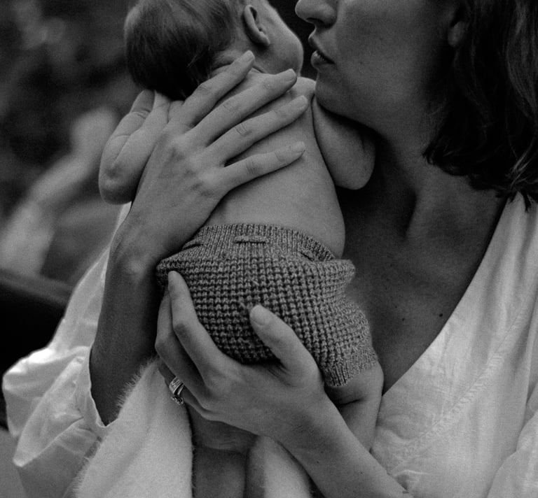 natural newborn photograph of mom holding baby looking over her shoulder