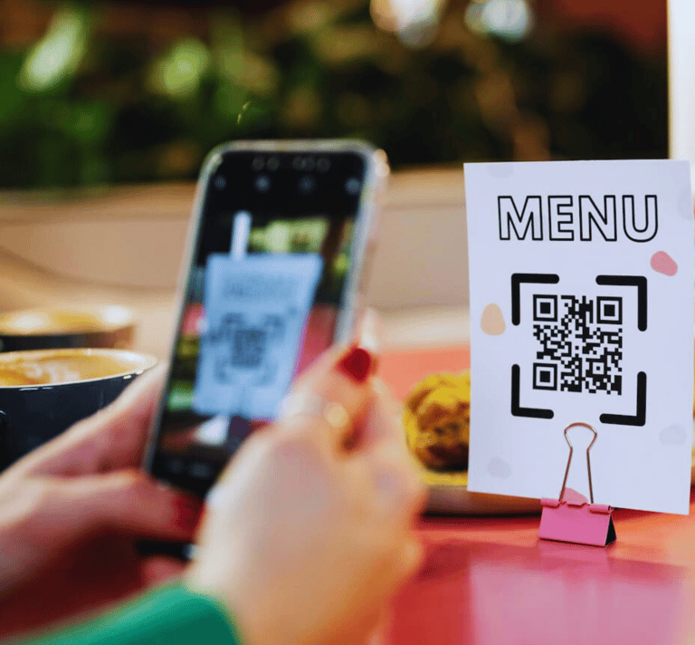 Um cliente usa seu smartphone para escanear um código QR no cardápio enquanto está sentado à mesa do