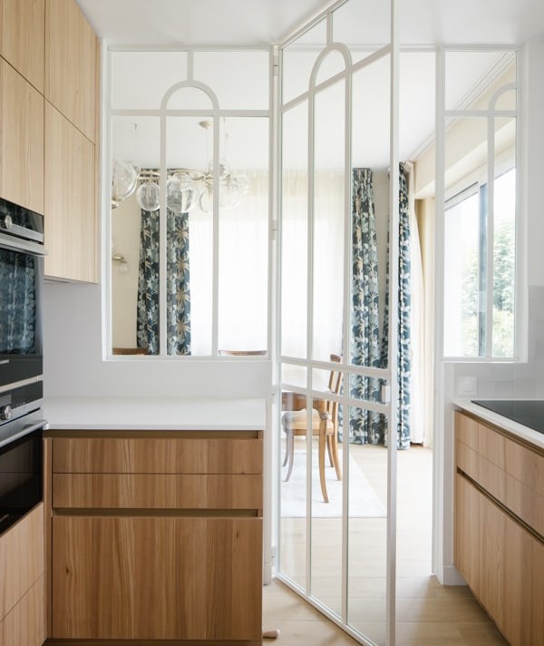 a kitchen with a large window and a table with chairs