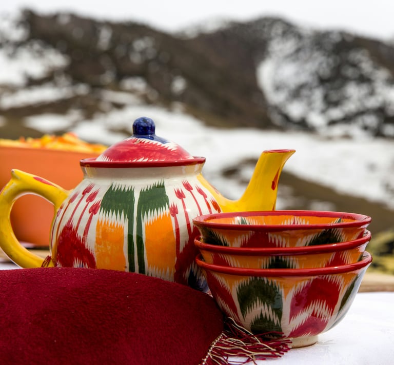 red and yellow ceramic teapot on red textile by Daniel Fox