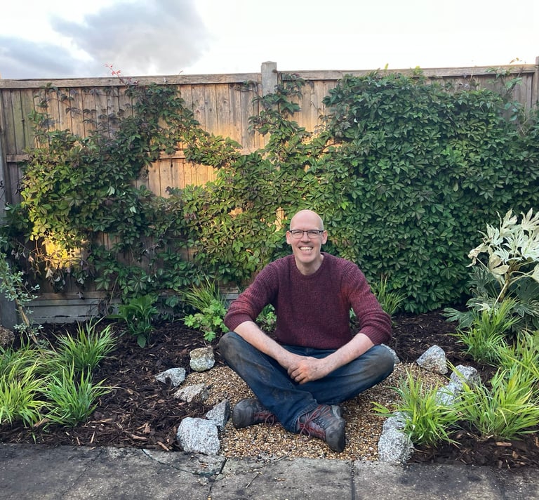 Garden designer Conor O'Donovan sitting in a shady corner garden in London