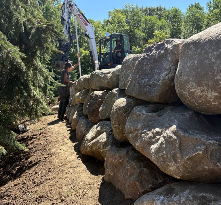 Boulder wall being checked for proper level