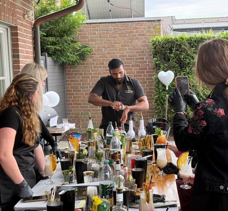 Professional mixologist at an outdoor mobile bar preparing cocktails for guests at a private event.