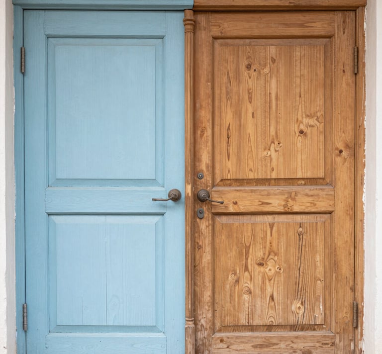 Rustic double entrance featuring one blue painted wooden door and one paint stripped wood door.