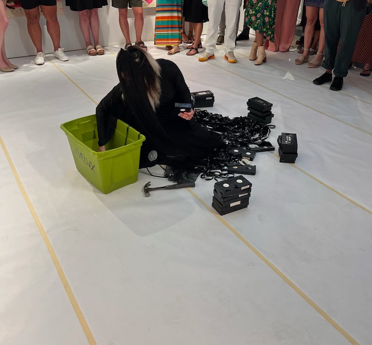 contemporary performance artist lvf.lvx pulling out vhs tapes in ritual performance tapes in drag