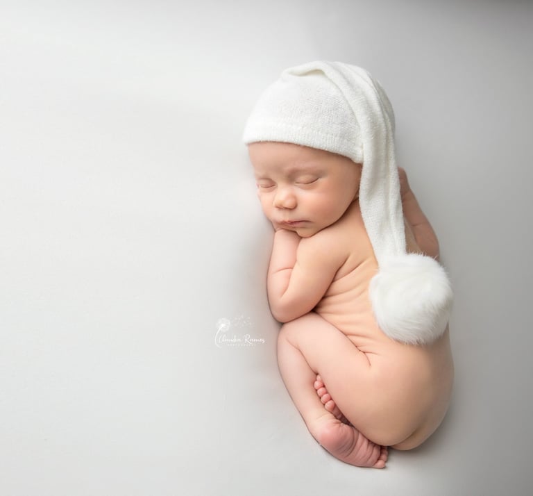 recién nacido dormido con gorrito blanco