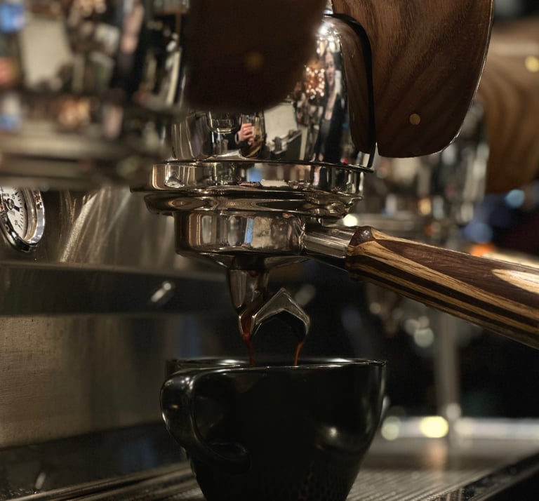 a cup of coffee being poured into a cup